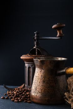 Coffee mill and cezve on the dark table vertical