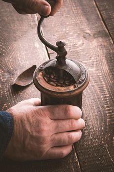 Old coffee mill in the hands vertical