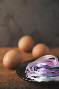 Blue ribbons in the plate with blurred eggs vertical