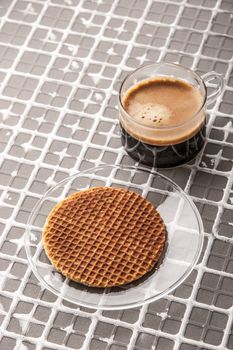 Cup of coffee with wafer on the relief background vertical