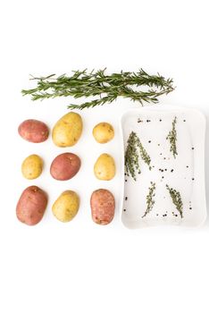 Raw potatoes with spices and herbs on the white background vertical