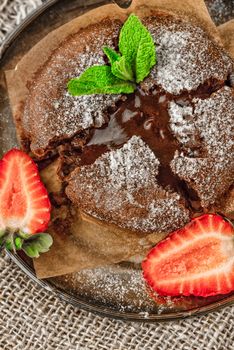 Chocolate fondant  with strawberry and mint on the metal plate vertical