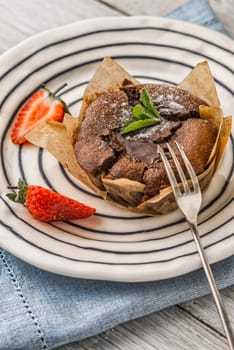 Chocolate fondant  with strawberry and mint on the ceramic plate vertical