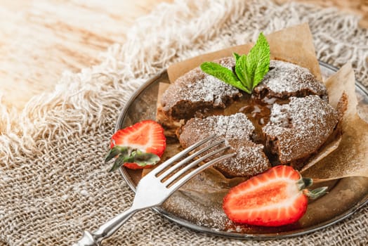 Chocolate fondant  with strawberry and mint on the metal plate horizontal