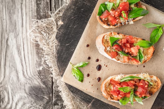 Bruschetta with tomatoes and basil on the wooden board top view