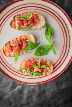 Bruschetta with tomatoes and basil on the stone table top view