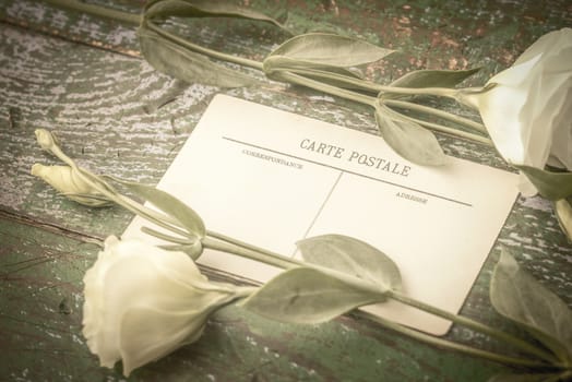 Postcard with white flowers on the wooden table