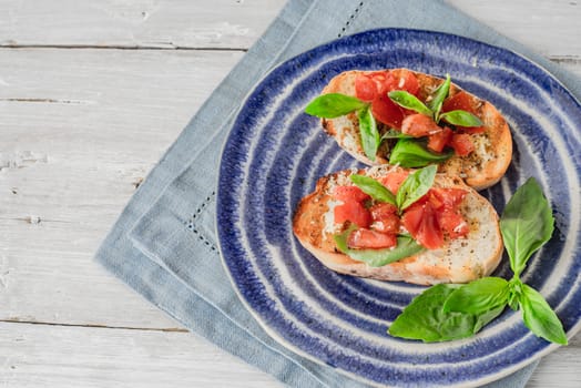 Bruschetta with tomatoes and basil on the ceramic plate horizontal