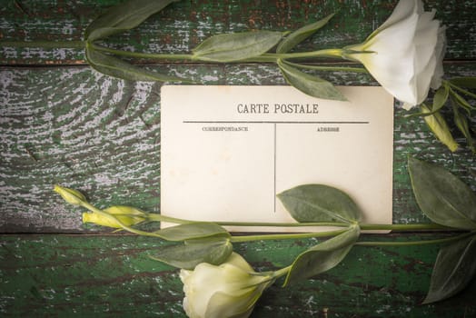 Postcard with white flowers on the wooden table top view