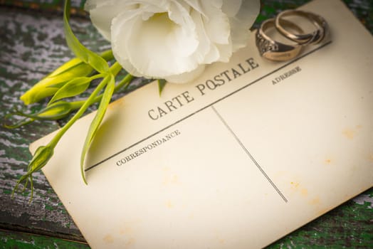 Postcards with ring and flowers on the wooden table