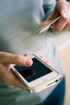 Woman with credit card ant mobile phone in the hand