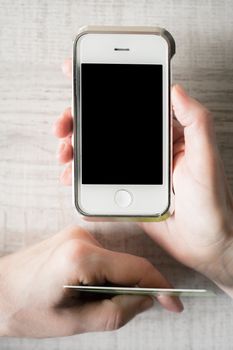 Hands with credit card and mobile phone vertical