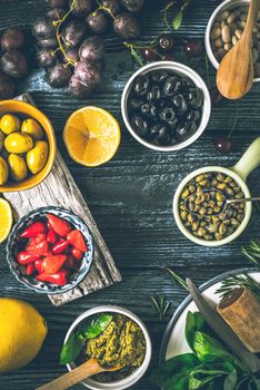 Concept of Mediterranean cuisine. Different fruit , herbs and appetizers on the  wooden table vertical