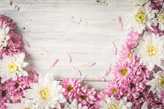 Frame of  white and pink flower on the white wooden table top view