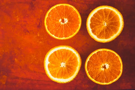 Orange slices on the terracotta background top view