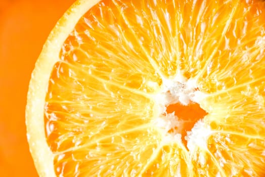 Orange slice on the orange background close-up