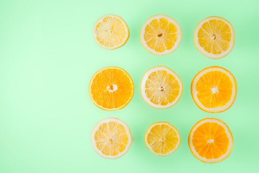 Lemon and orange slices on the  light blue background top view