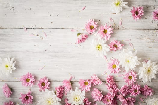 Pink and white flowers on the white wooden table top view