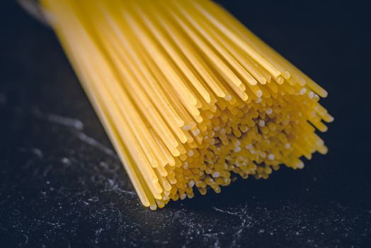 Raw spaghetti on the black stone background  horizontal