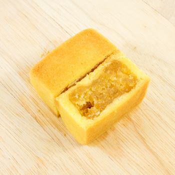 The tasty Taiwanese pineapple pastry cake with egg yolk on the wooden plank.