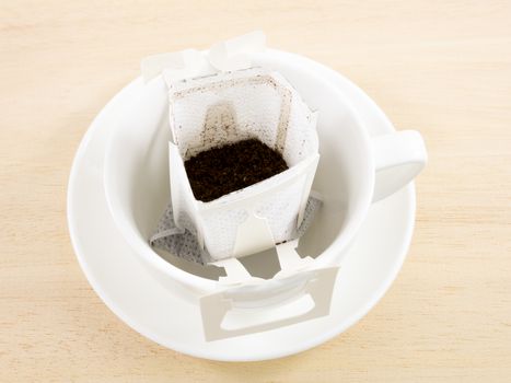 The instant freshly brewed coffee drip bag on white coffee cup.