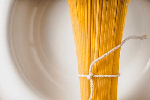 Raw spaghetti  on the white plate close-up