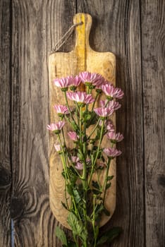 Pink flowers on the wooden board vertical
