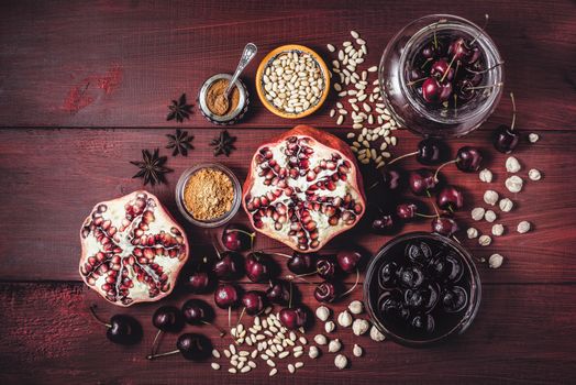 Still life with pomegranate , cherry and spices on the red wooden table. Concept of oriental fruits horizontal
