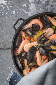 Paella in the pan on the metal background vertical