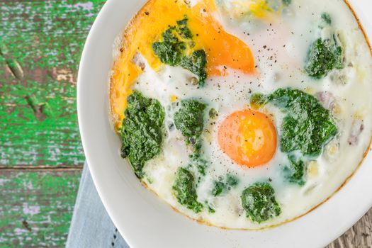 Florentine eggs with pureed spinach on the wooden table
