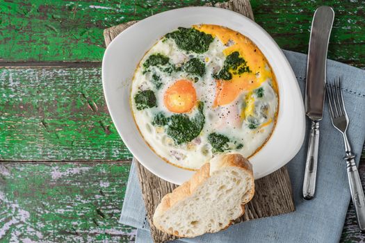 Florentine eggs with pureed spinach on the wooden table horizontal