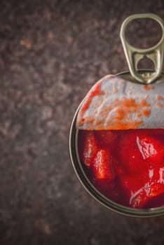 Chopped tomatoes in the metal can in the stone table vertical