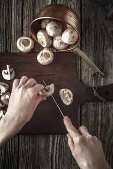 Cutting mushrooms on the wooden board vertical