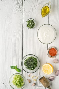 Natural yogurt and different seasoning on the white wooden table vertical