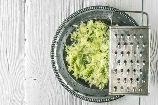Grated cucumber in the metal plate top view