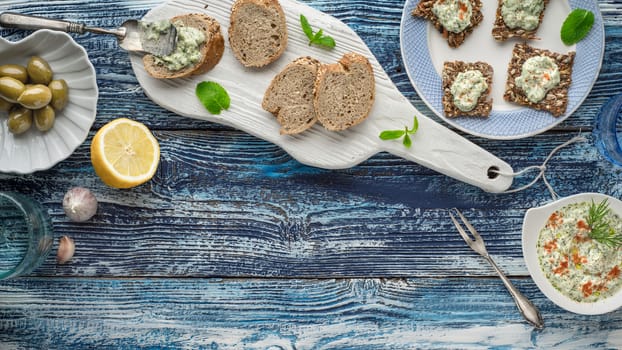 Bread with tzatziki on the blue wooden table with accessorize horizontal