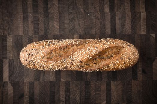 Bread with grains and seeds on the wooden board top view