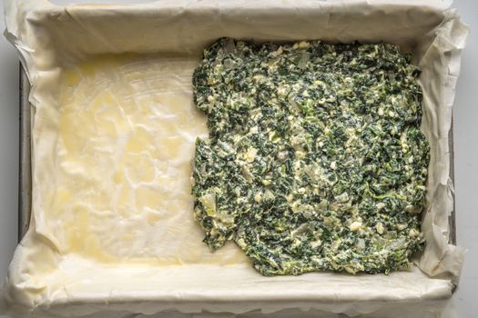 Placing the filling for spanakopita on the dough