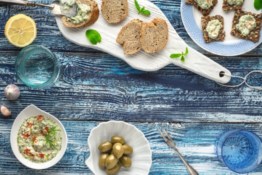 Bread with tzatziki on the blue wooden table with accessorize
