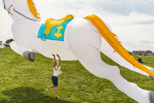 Little girl playing with a kite in a park