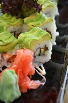 Veggie sushi roll on plate with avocado, kale and cucumber