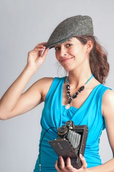 Beautiful woman in the pose of a 1930's style paparazzi after geting a great photo of a movie star.