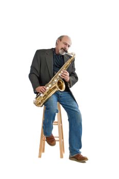 Adult male playing a tenor saxaphone while seated isolated on pure white.