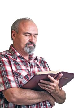 An adult man studies a Bible thoughtfully while standing