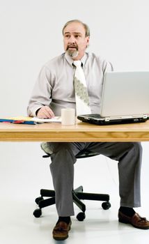 A businessman seated at a desk while attatched to an oxygen concentrator.