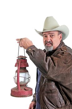 Mature cowboy leaving the barn with a kerosene lantern. Isolated on a white background.