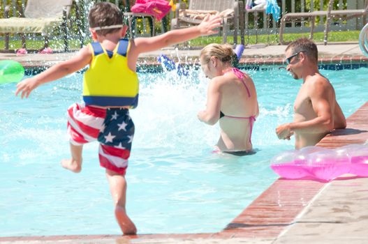 Young Parents enjoying time at the swimming pool with their children.