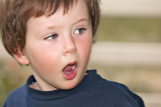 Cute little boy showing surprise and disbelief on his expressive face with slight motion blur on the edge of his face for effect.