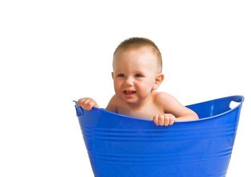 Cute baby boy playing in a blue plastic tub.