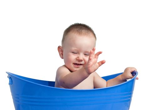 Baby playing in a blue tub with his eyes closed. Isolated with a clipping path